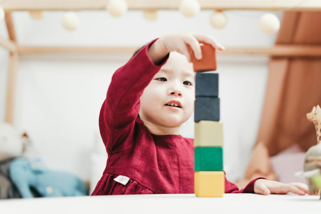 A Toddler at Little Big People Early Learning A toddler stacking blocks at Little Big People Early Learning.